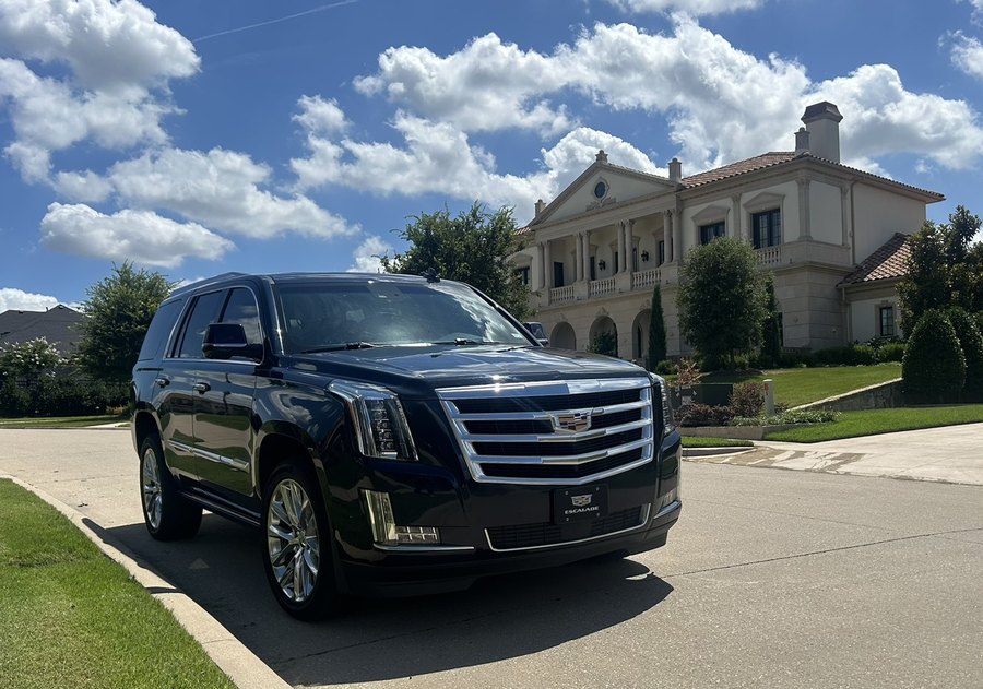 Black Cadillac Escalade detailed inside and out, parked in front of a mansion